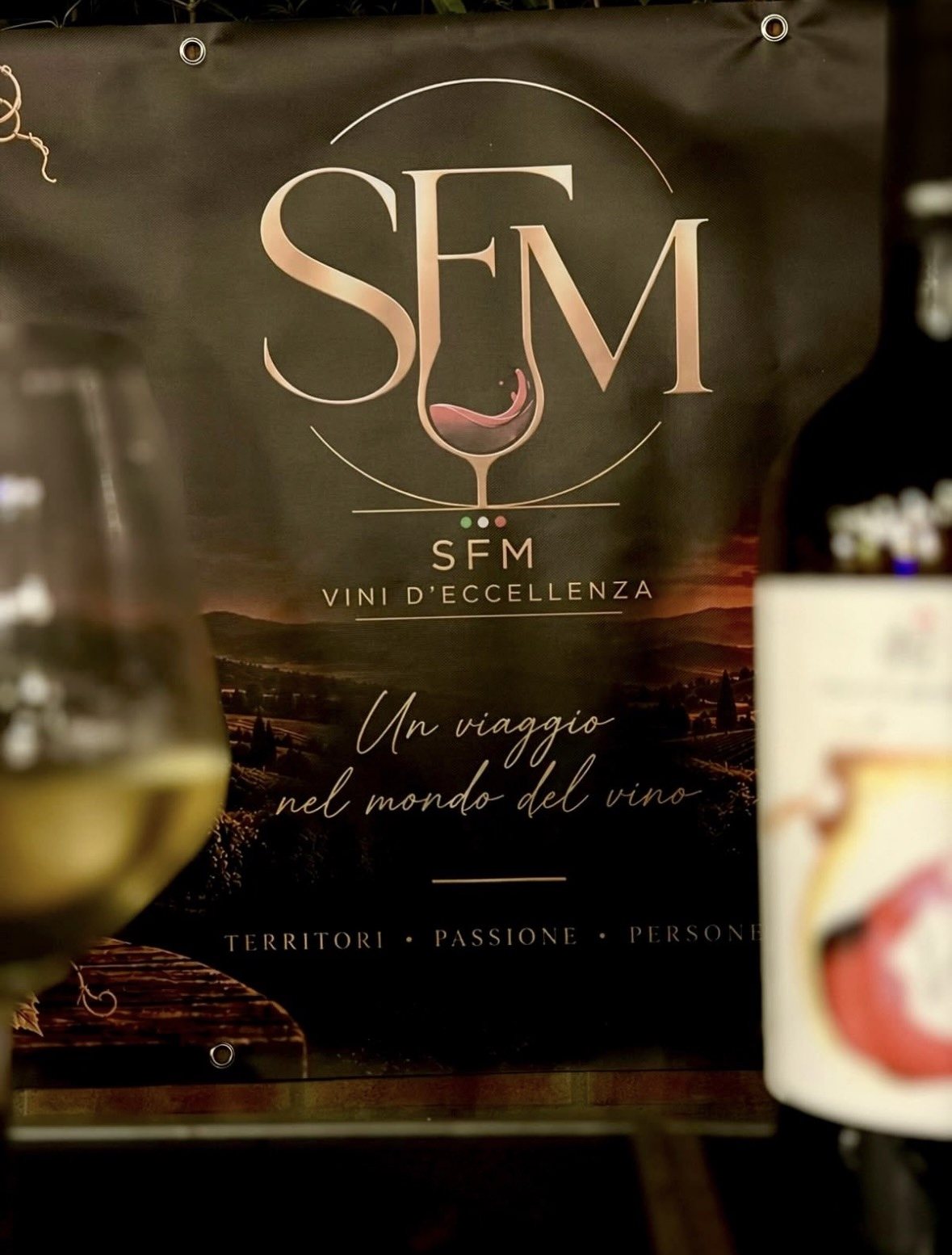 Il banner S.F.M. Vini d'eccellenza durante una degustazione: «Un viaggio nel mondo del vino»